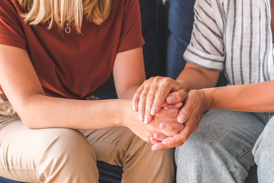 two people gently holding hands, conveying connection and empathy, with an emphasis on emotional support 13